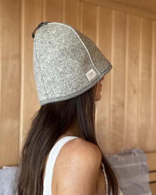 Woman wearing an EIR studio light grey 100% virgin wool sauna hat